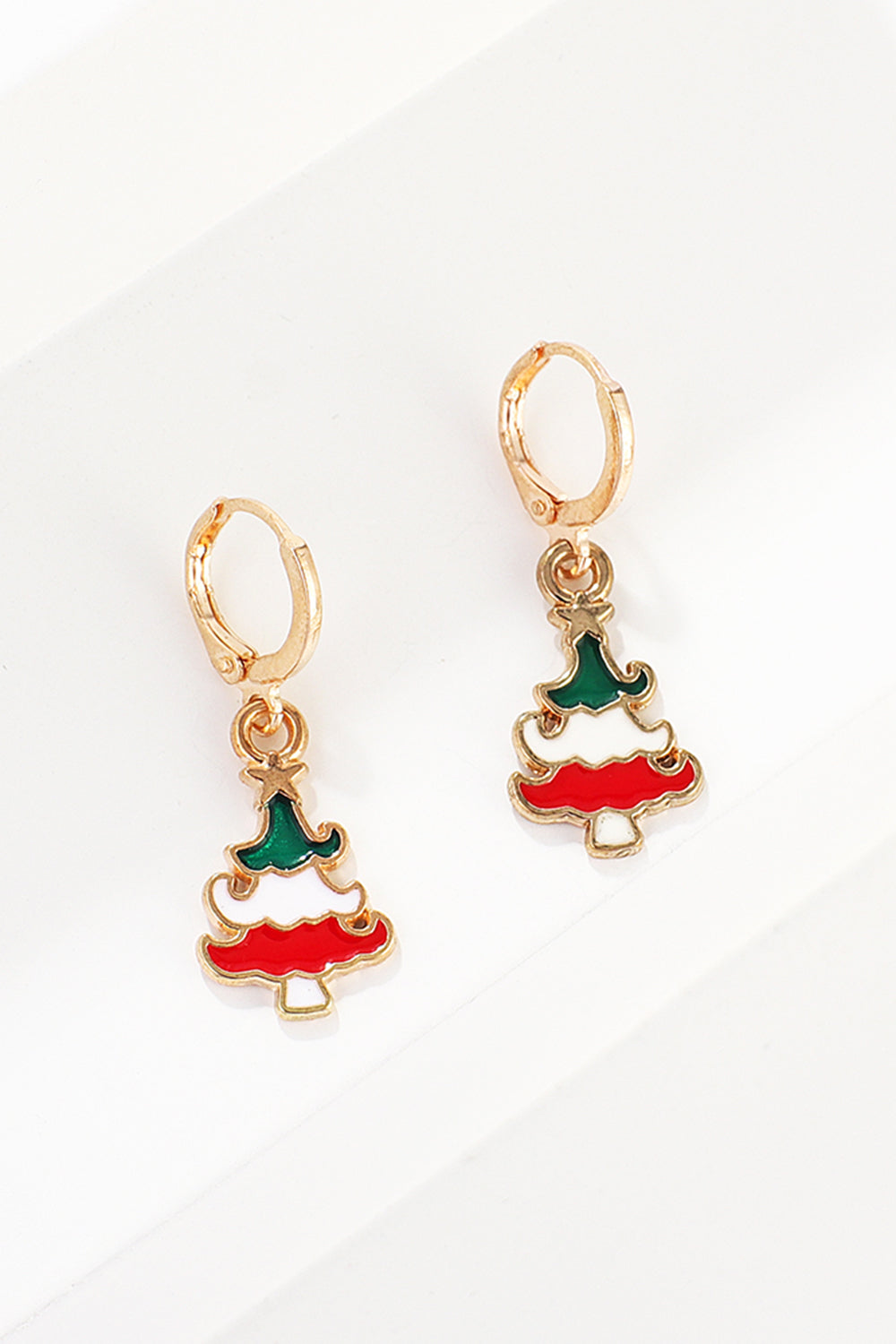 Festive Christmas tree hoop earrings with red, white, and green enamel detail.