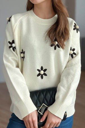 Cream embroidered floral raglan knit sweater with beaded flower details.