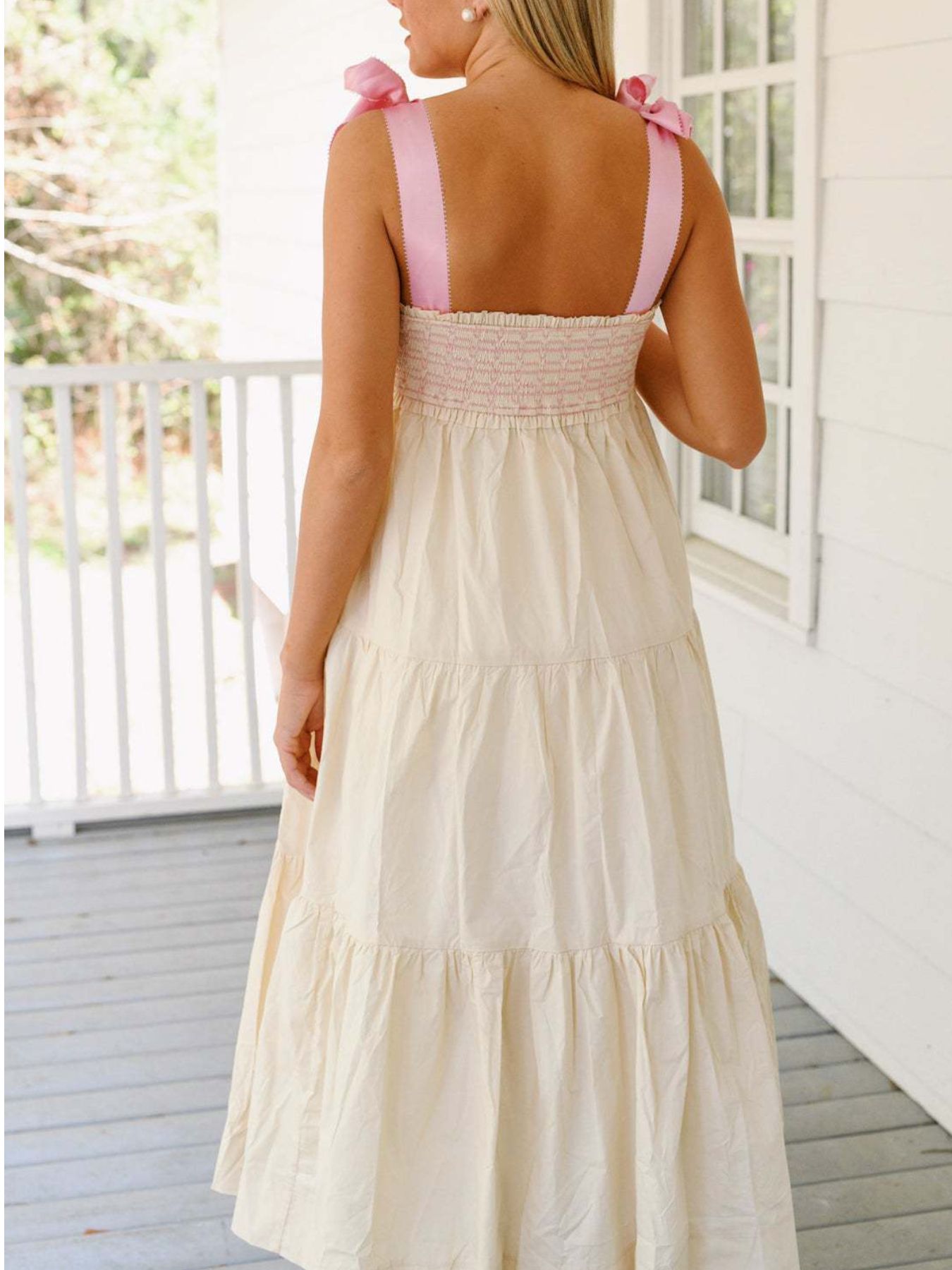 Cream tiered midi dress with smocked bodice and pink tie shoulder straps.