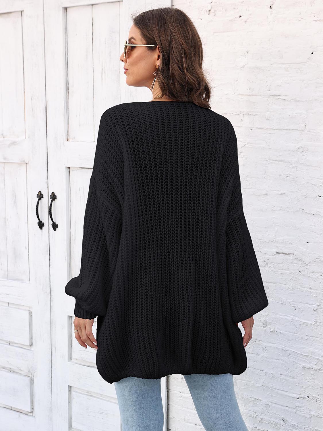 Black open knit cardigan with balloon sleeves and a relaxed fit.