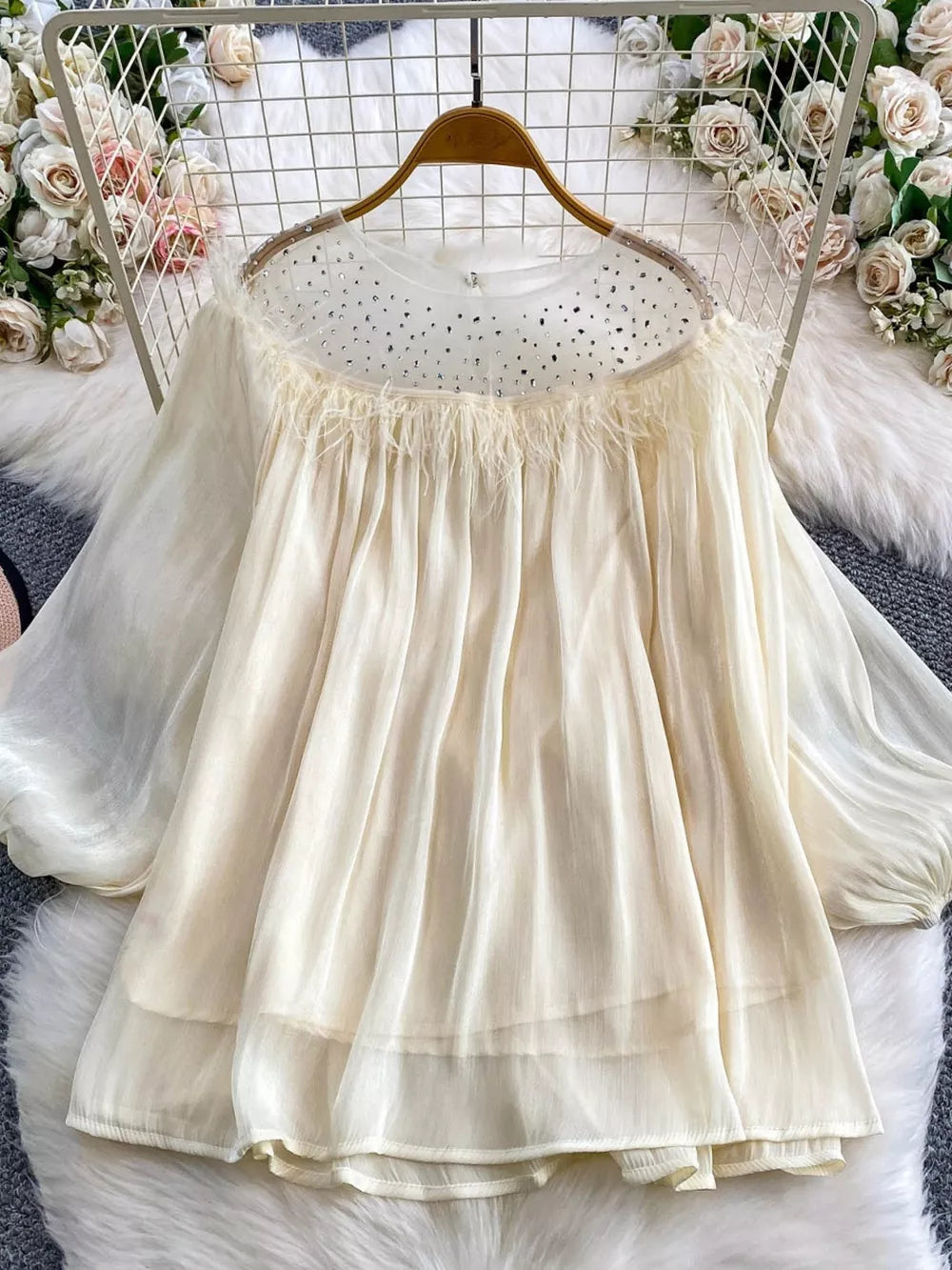 Apricot sheer blouse with rhinestone neckline and feather trim.