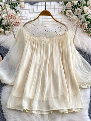 Apricot sheer blouse with rhinestone neckline and feather trim.