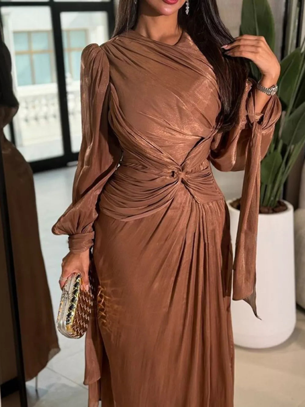 Brown twisted draped maxi dress with ruched bodice, long sleeves, and knot detail.