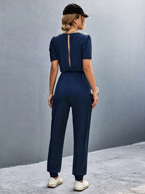 Dark blue jumpsuit with puffed short sleeves and back cutout detail.