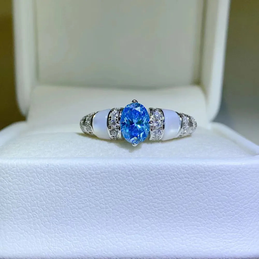 Silver ring with blue oval moissanite and mother-of-pearl accents