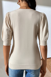 Camel knit sweater with puff sleeves and ribbed cuffs and hem.
