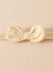Cream baby headband with a large fabric bow detail
