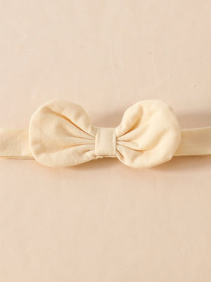 Cream baby headband with a large fabric bow detail