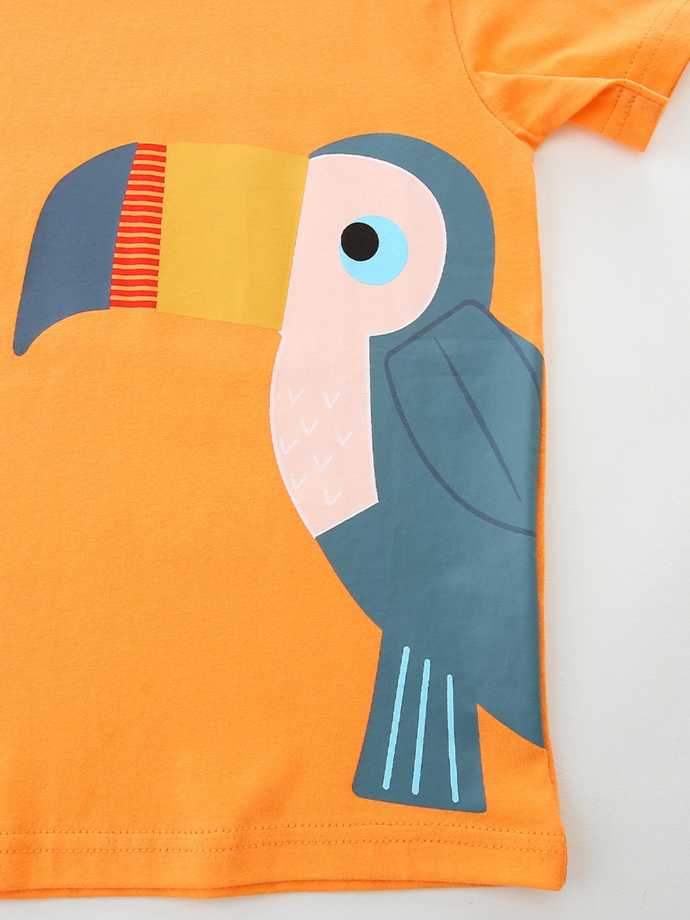 Orange cotton t-shirt with a playful toucan graphic, crew neck, and short sleeves.