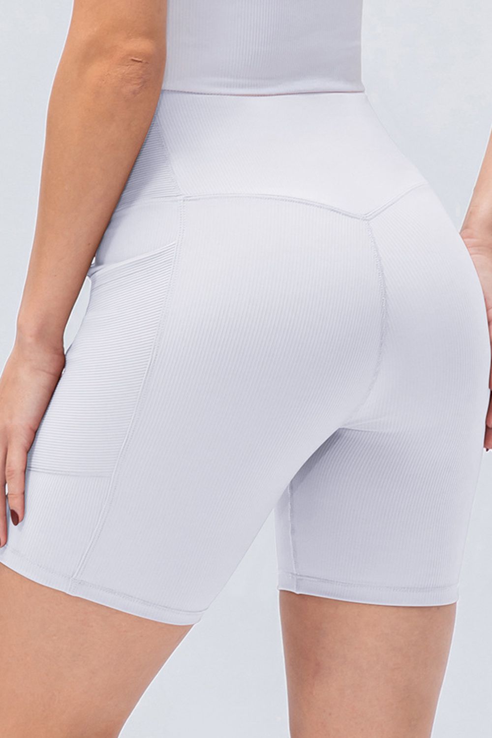 Light blue ribbed bike shorts with cross-waist detail and side pockets.