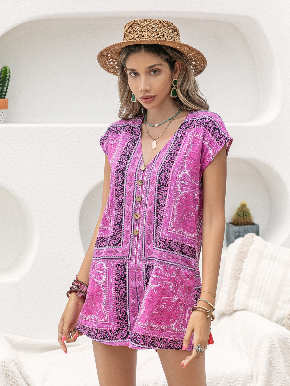 Bohemian print playsuit in red-violet with cap sleeves and button front.
