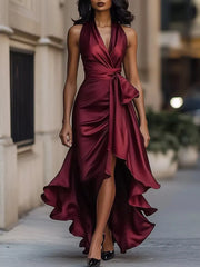 Wine red satin high-low ruffled maxi dress with cinched waist and bow detail.