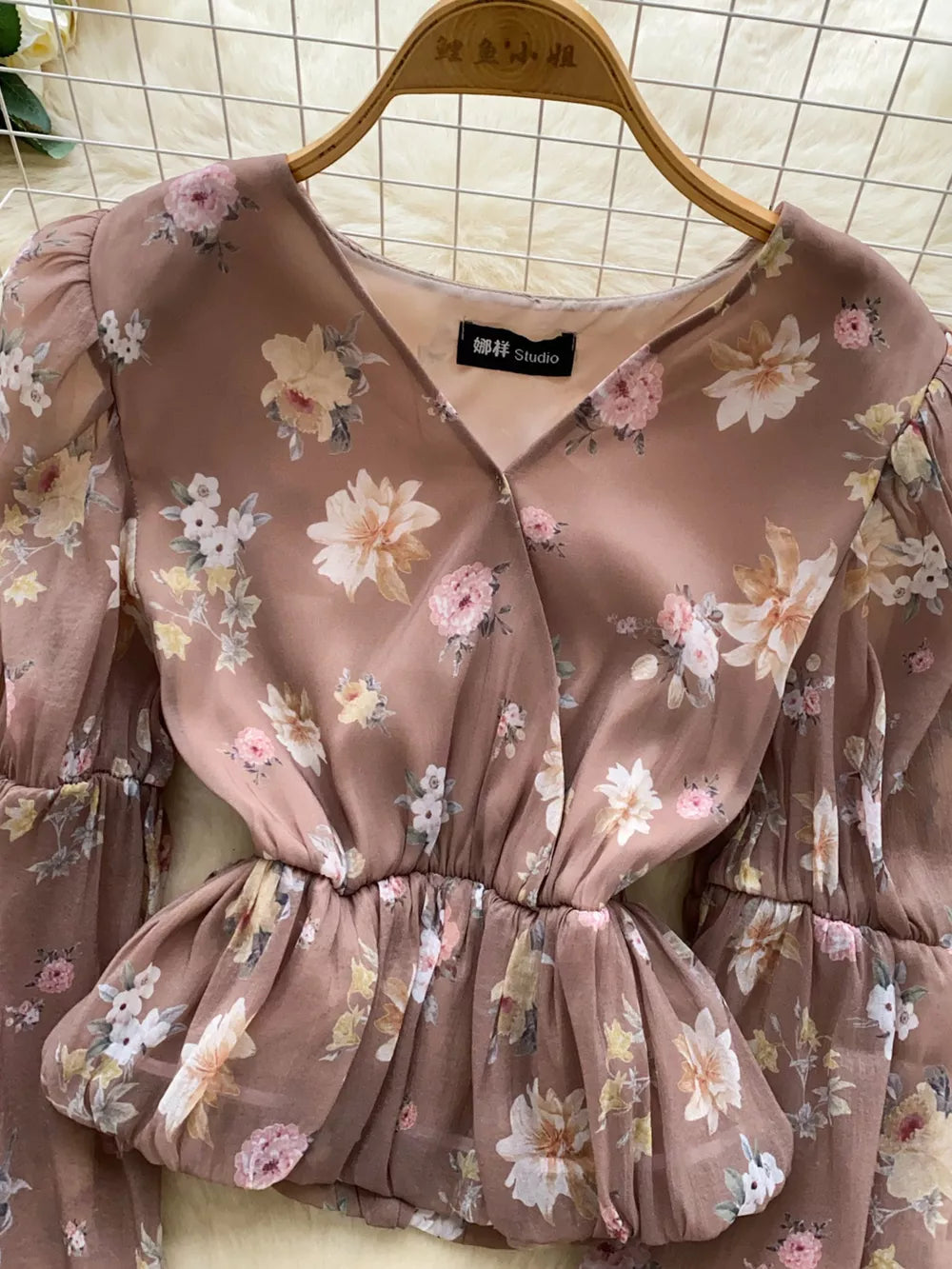 Brown floral chiffon blouse with V-neck and balloon sleeves.