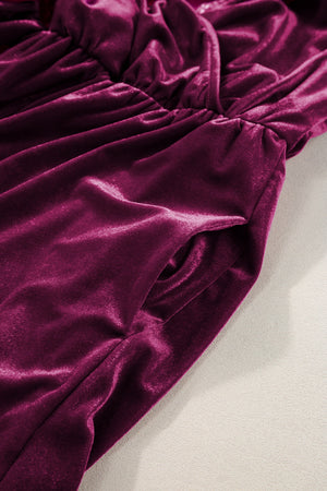 Burgundy velvet wrap romper with ruffled detail and side pockets.