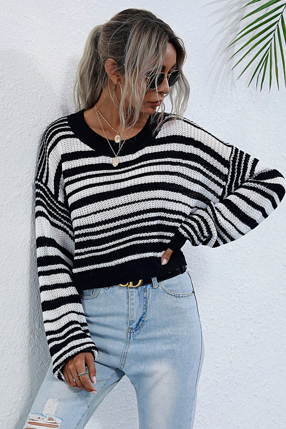 Cropped black and white stripe knit crew neck sweater with long sleeves.
