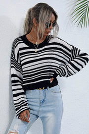 Cropped black and white stripe knit crew neck sweater with long sleeves.
