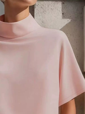 Blush pink polyester mock neck t-shirt with relaxed short sleeves.