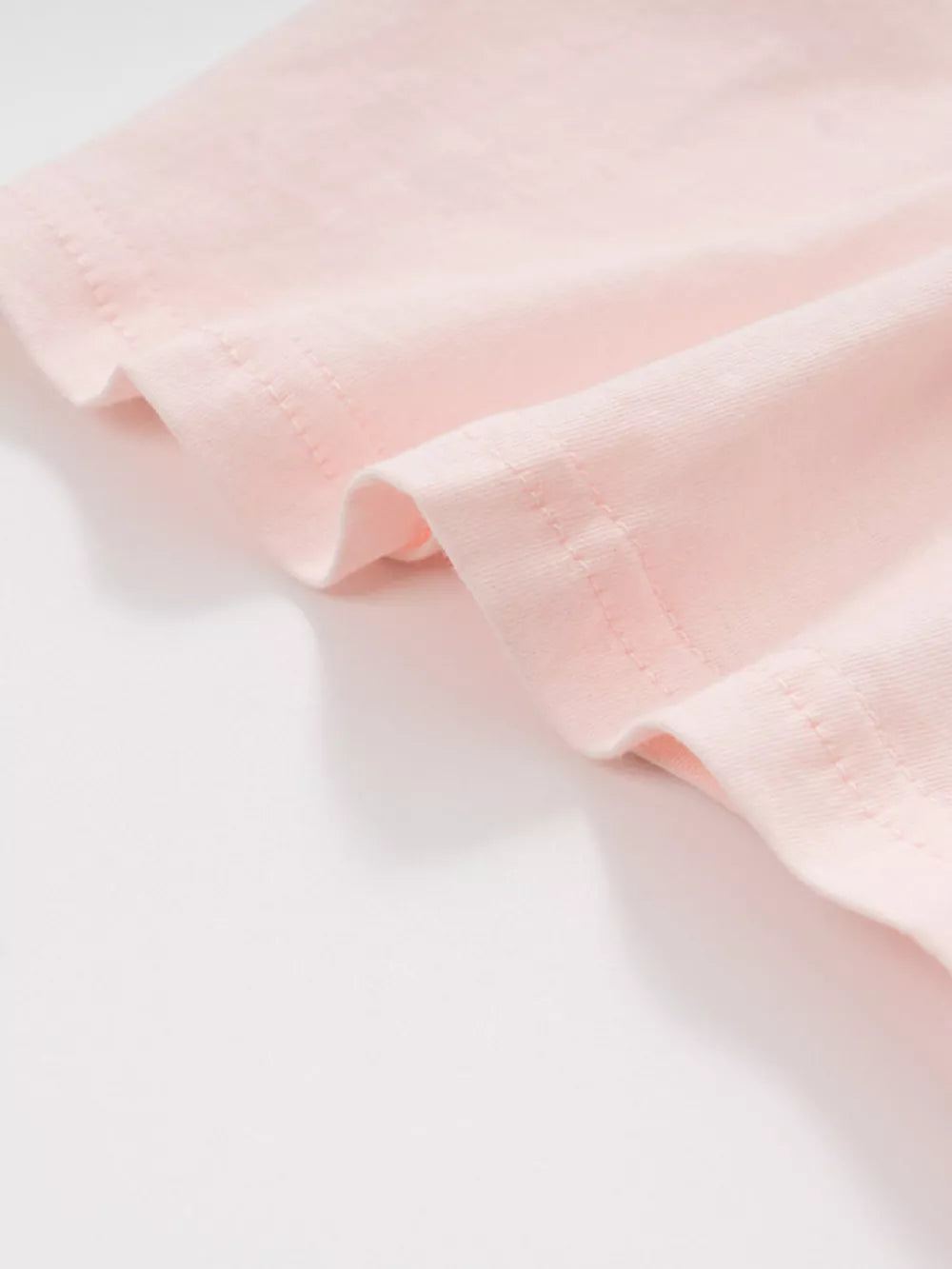 Pink cotton toddler t-shirt detail showing hem stitching.