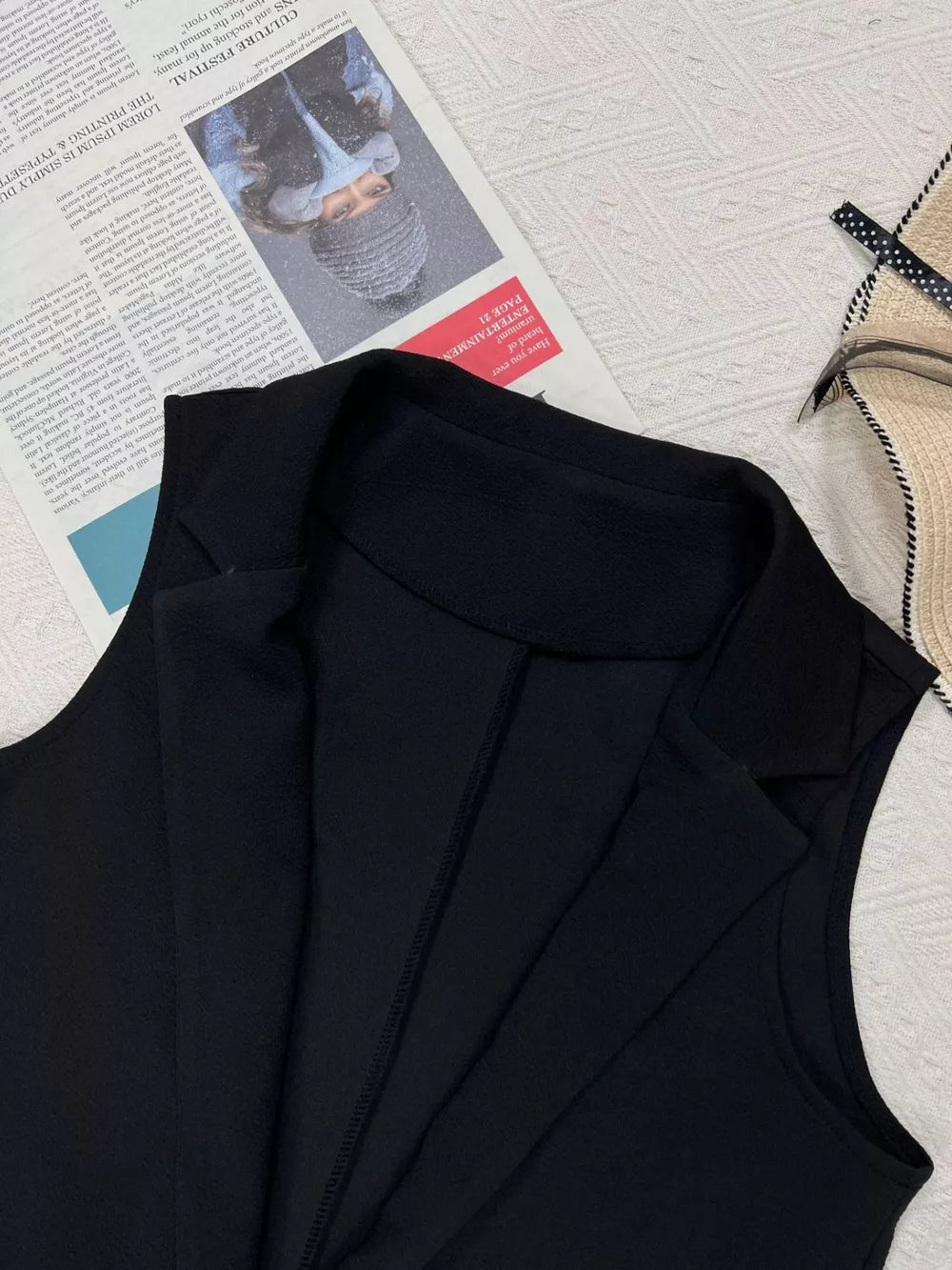 Black longline vest coat with notch collar and tailored seams.