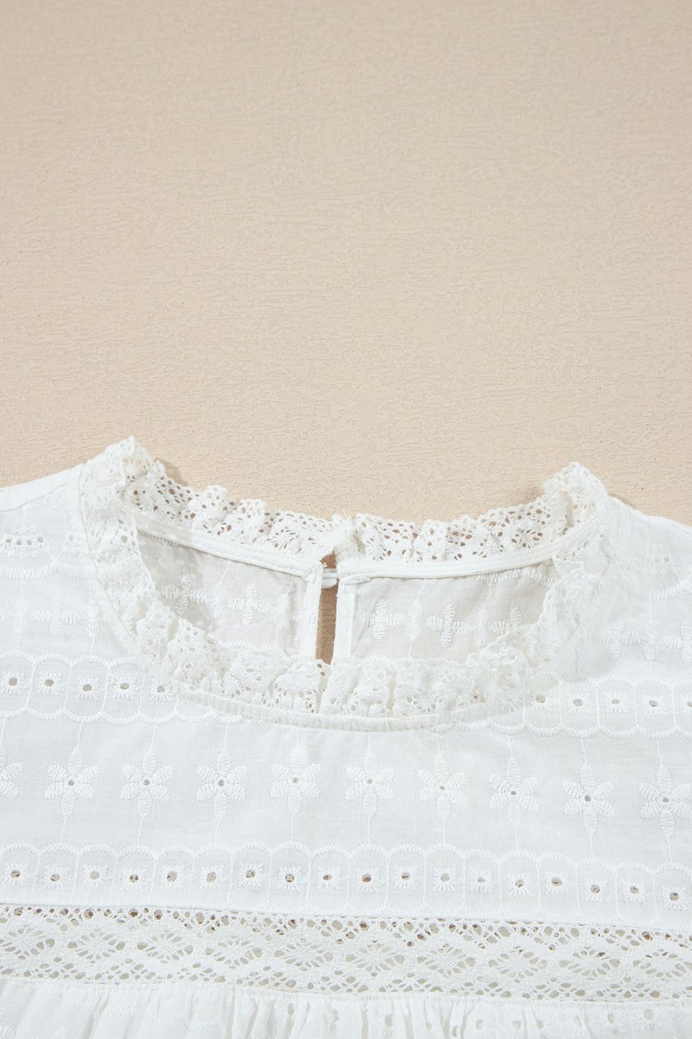White eyelet yoke blouse with ruffle trim and lace details.