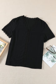 Black textured dot blouse with lace trim V-neck and short sleeves.