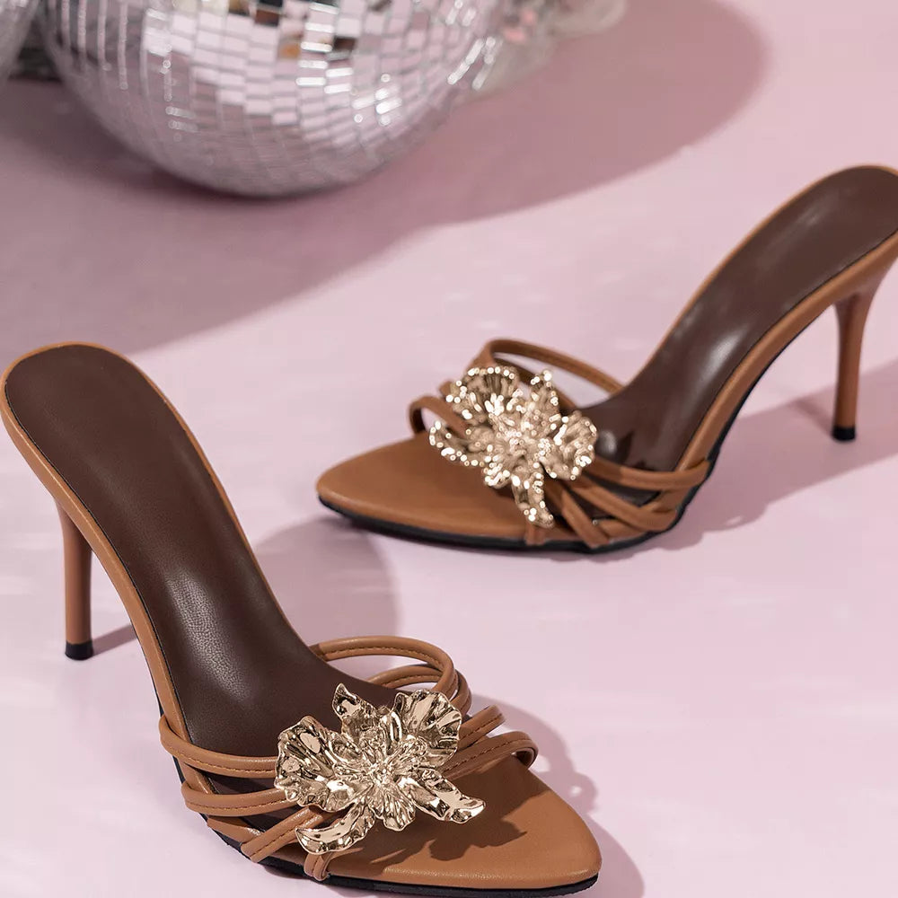 Apricot heeled sandals with gold floral embellishments and thin straps.