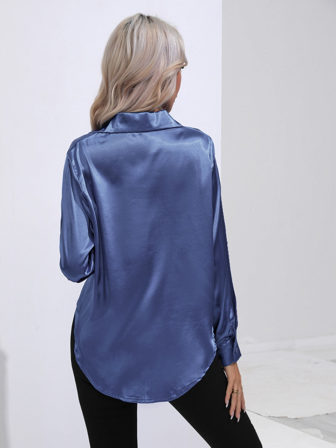 Royal blue satin tie-front blouse with buttoned cuffs and a curved hem.