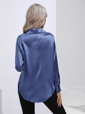 Royal blue satin tie-front blouse with buttoned cuffs and a curved hem.