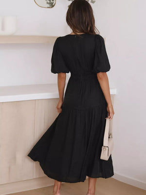 Black midi dress with puff sleeves, cinched waist, and tiered skirt.