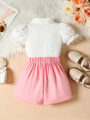 Toddler pink shorts with white puff sleeve top and collar detail.