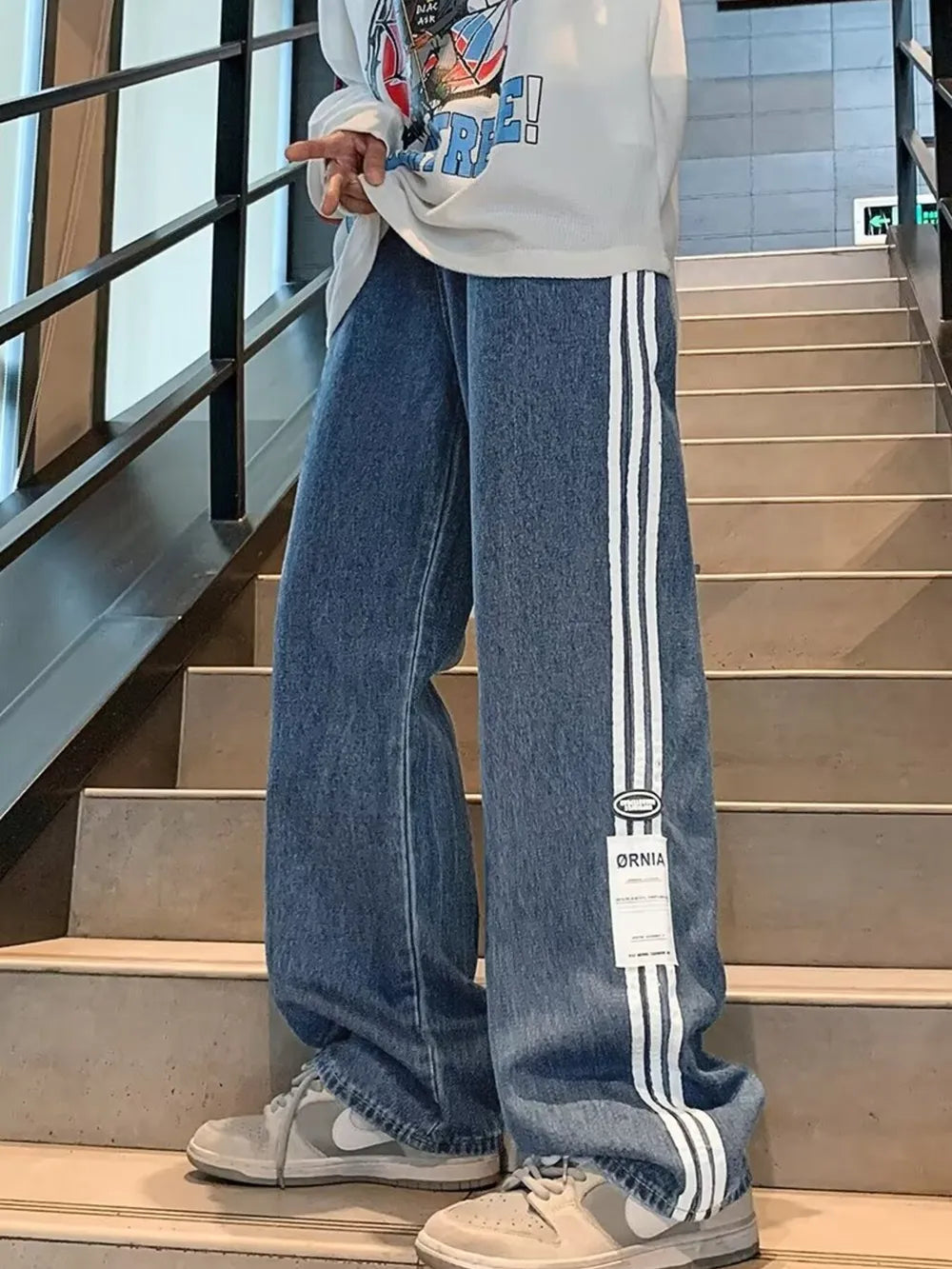 Men's blue oversized wide-leg jeans with white side stripes and a casual fit.
