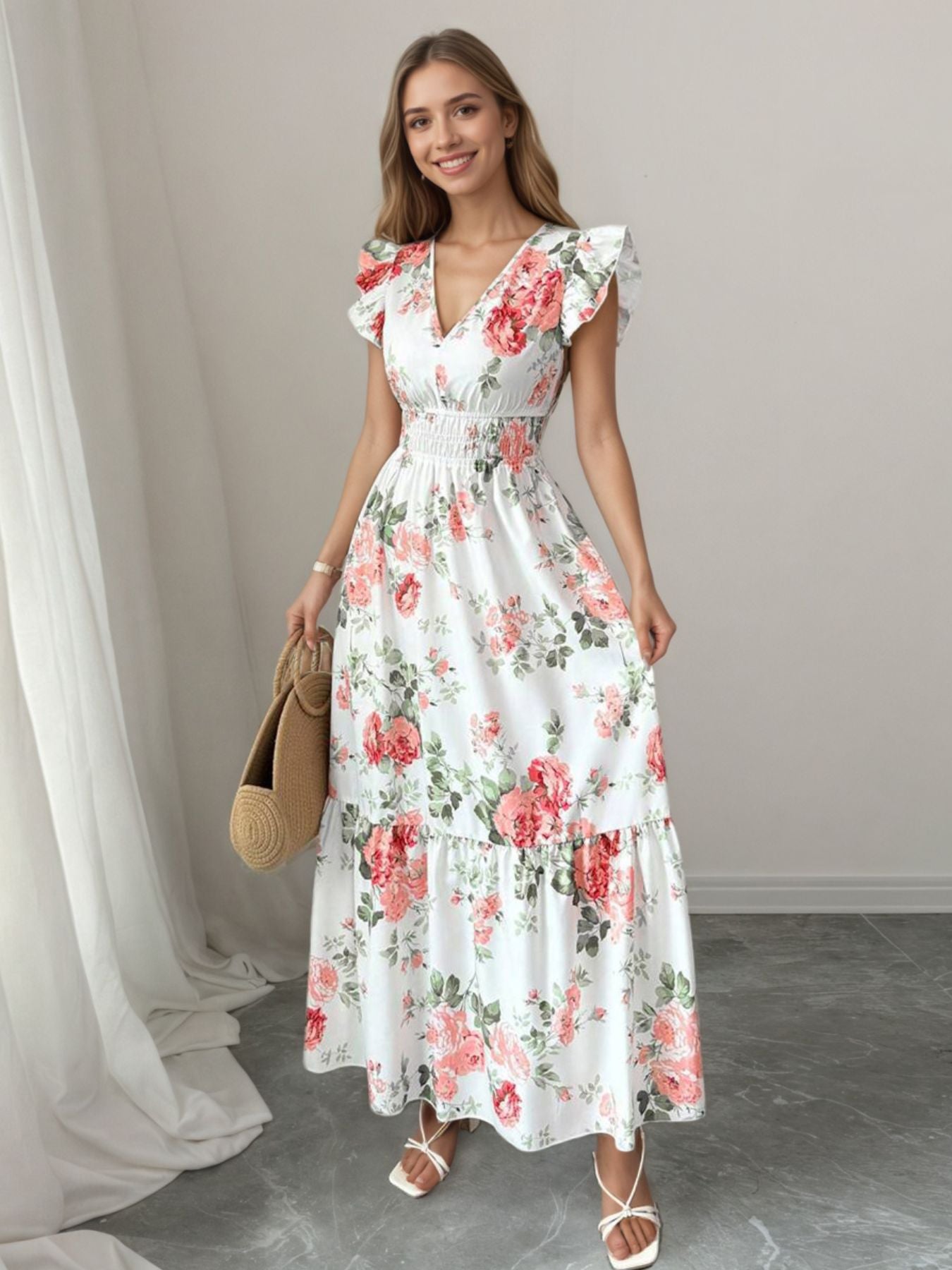 White floral maxi dress with ruffle sleeves, V-neck, and smocked waist.