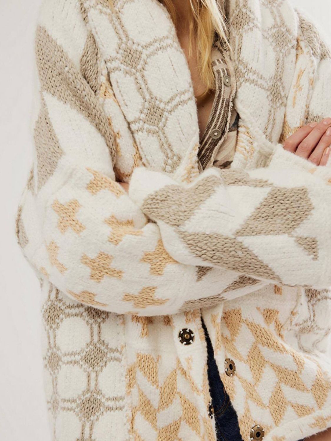Geometric patchwork knit cardigan with button front in cream, tan, and beige.