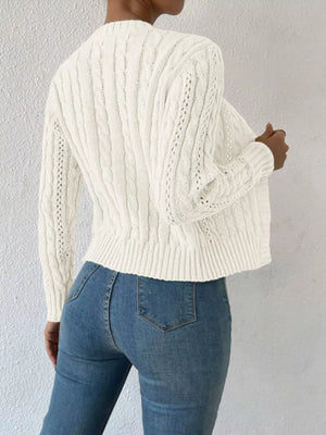 White cable-knit button-front cardigan with open knit details on sleeves and back.