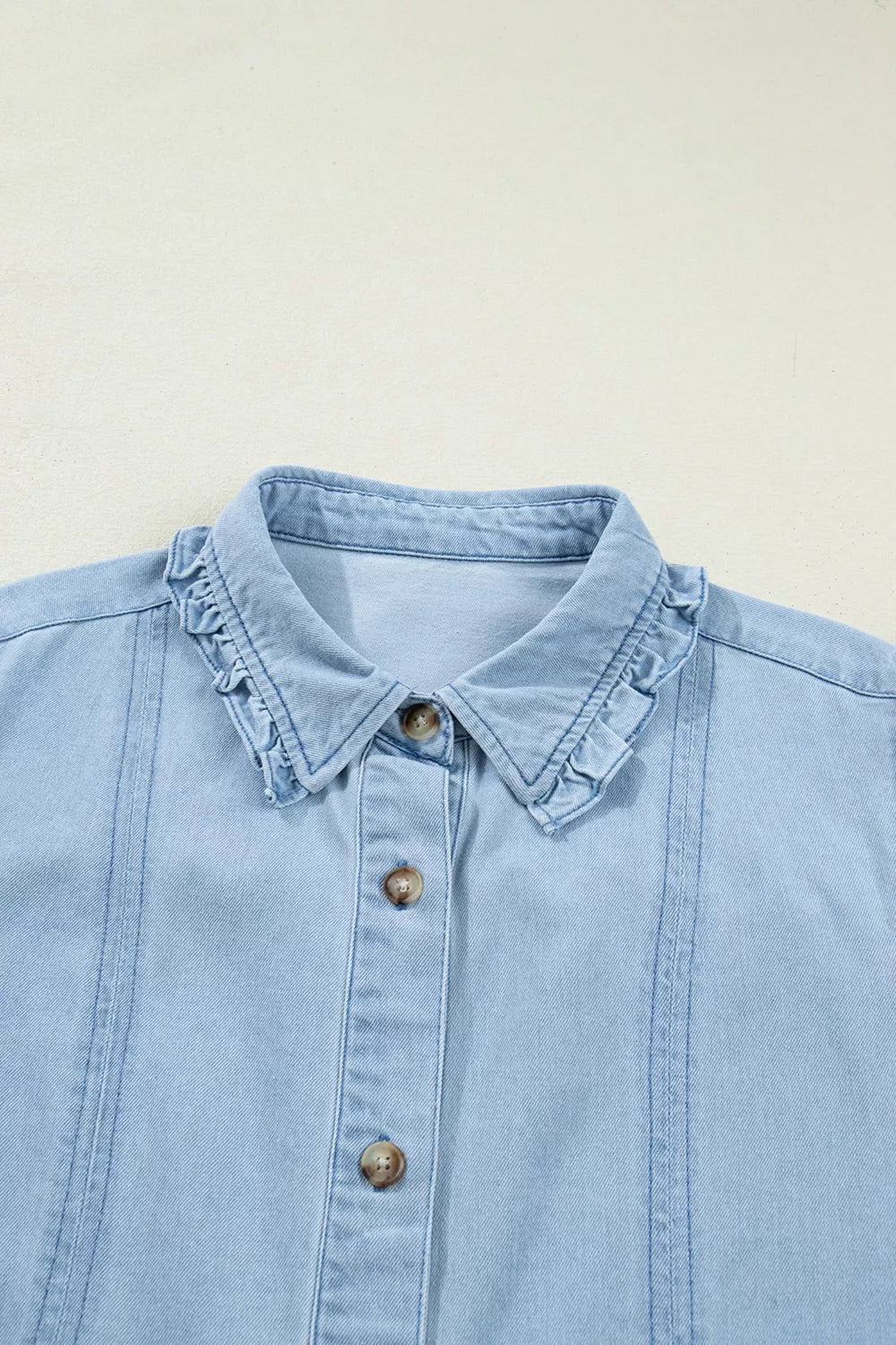 Light blue denim shift dress with ruffled collar and button front detail.