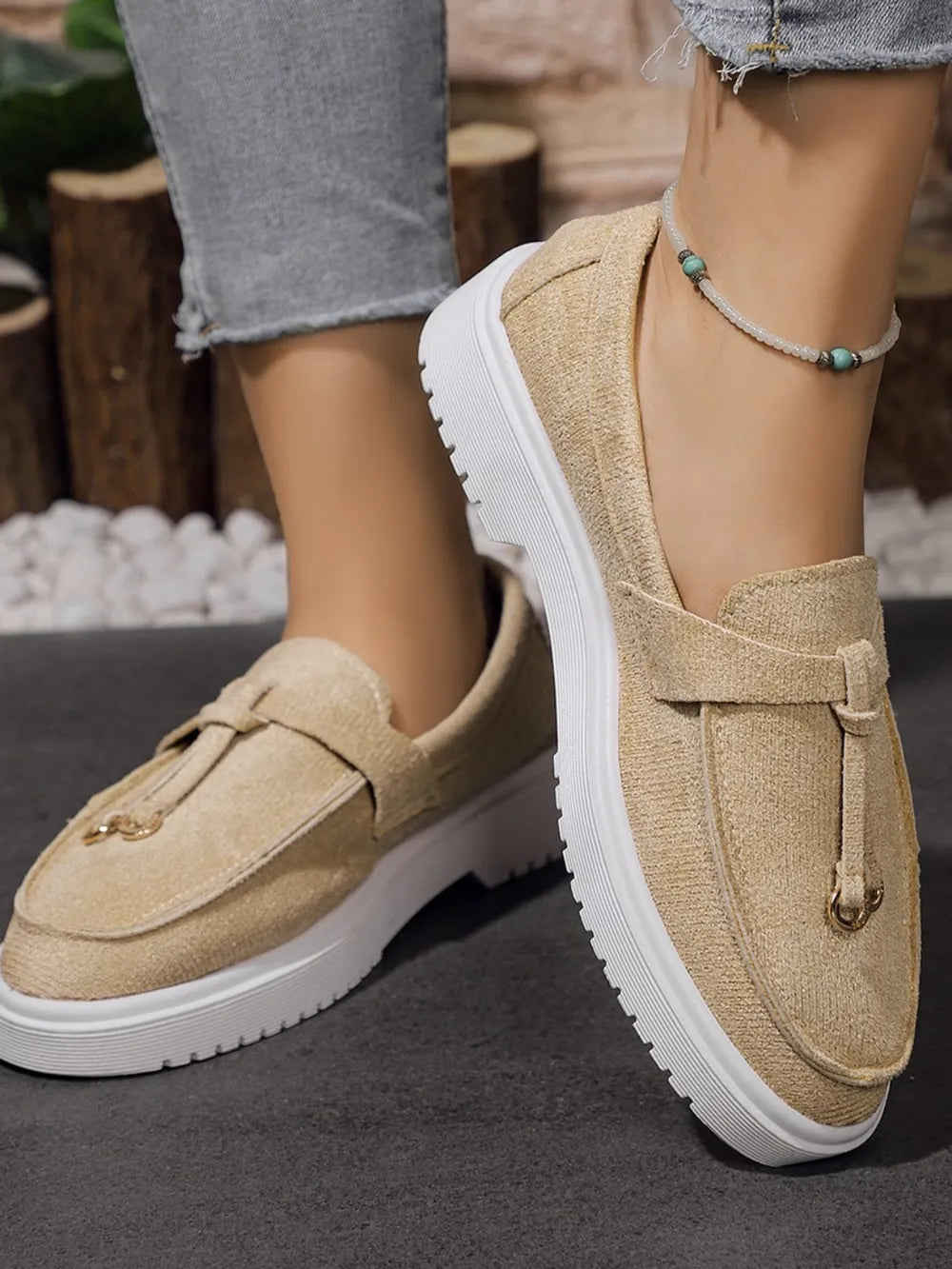 Beige suede loafer slides with tassel detail and gold hardware.