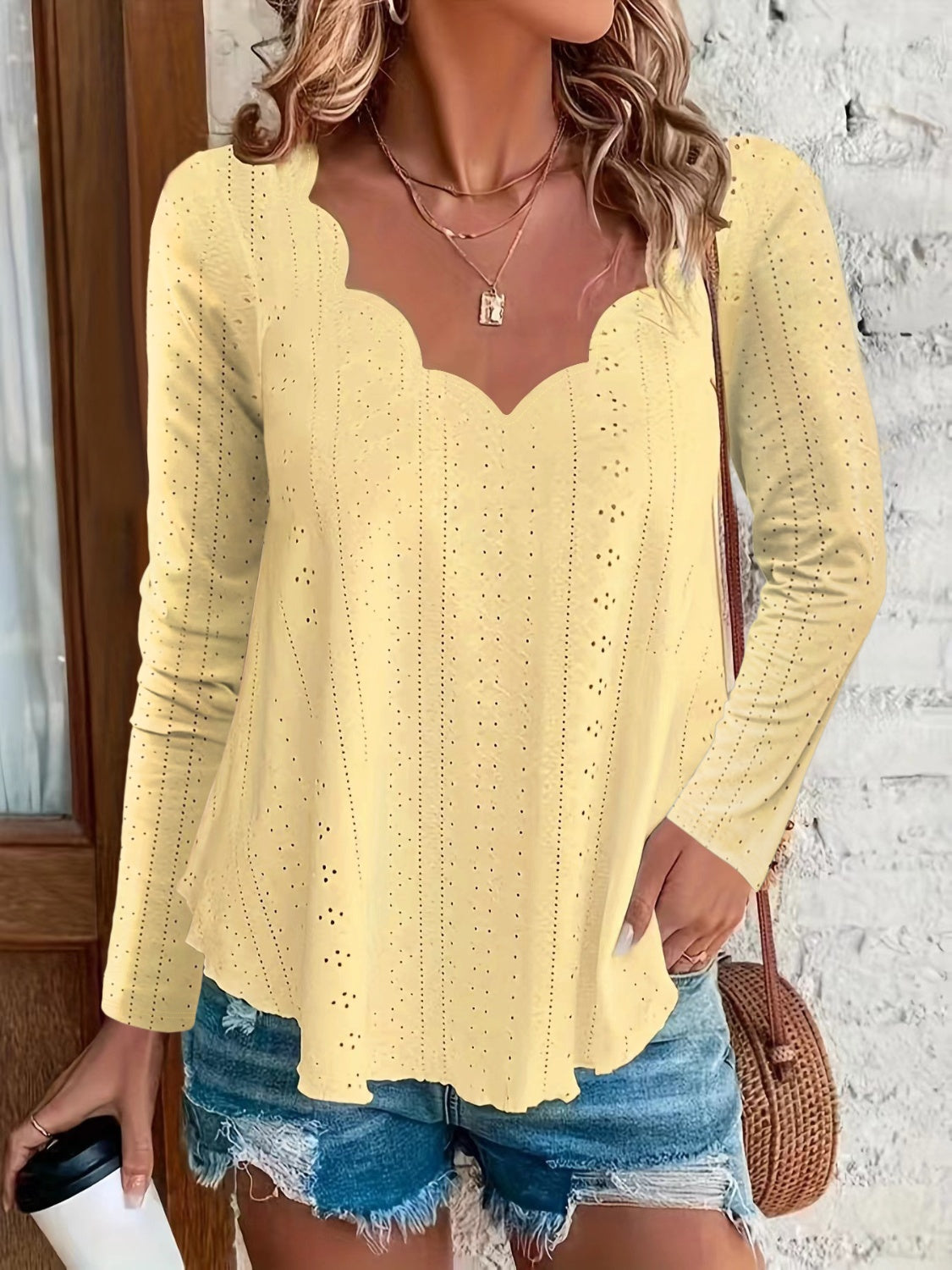 Light yellow scalloped eyelet yoke blouse with long sleeves and a V-neckline.