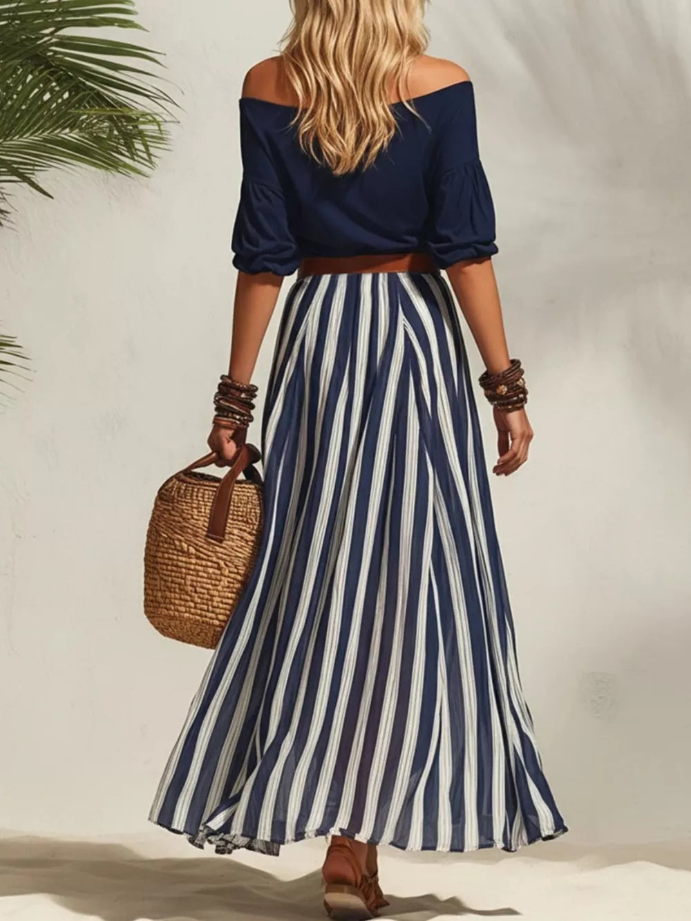 Navy off-shoulder top with puffed sleeves and a blue and white striped maxi skirt, belted.