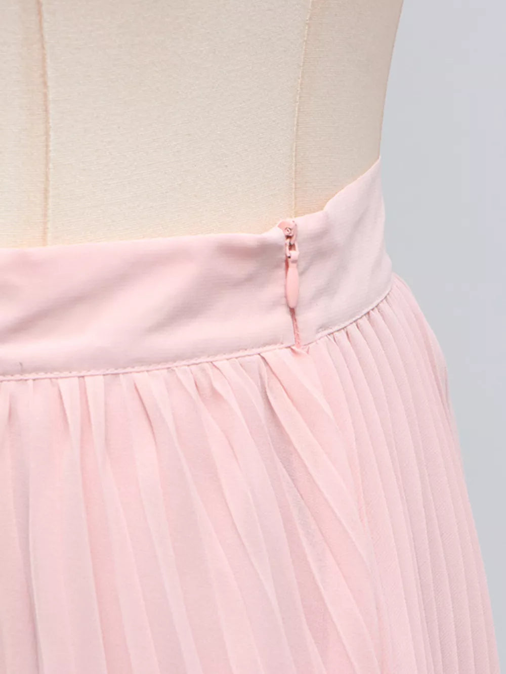 Pink pleated skirt with zipper detail, part of a two-piece ensemble.