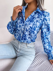 Royal blue floral print blouse with shirred cuffs and button front.