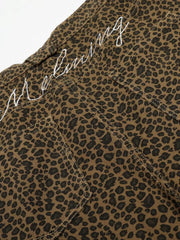 Men's brown leopard print capris with white embroidered text detail.