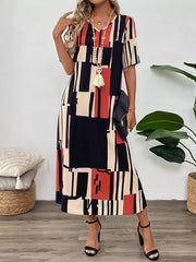 Geometric V-neck midi dress in dark blue, red, and cream abstract print.