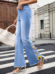 Light wash denim flare maternity jeans with embroidered floral detail on the leg