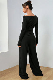 Black boat neck loungewear set with long sleeves and wide-leg pants.