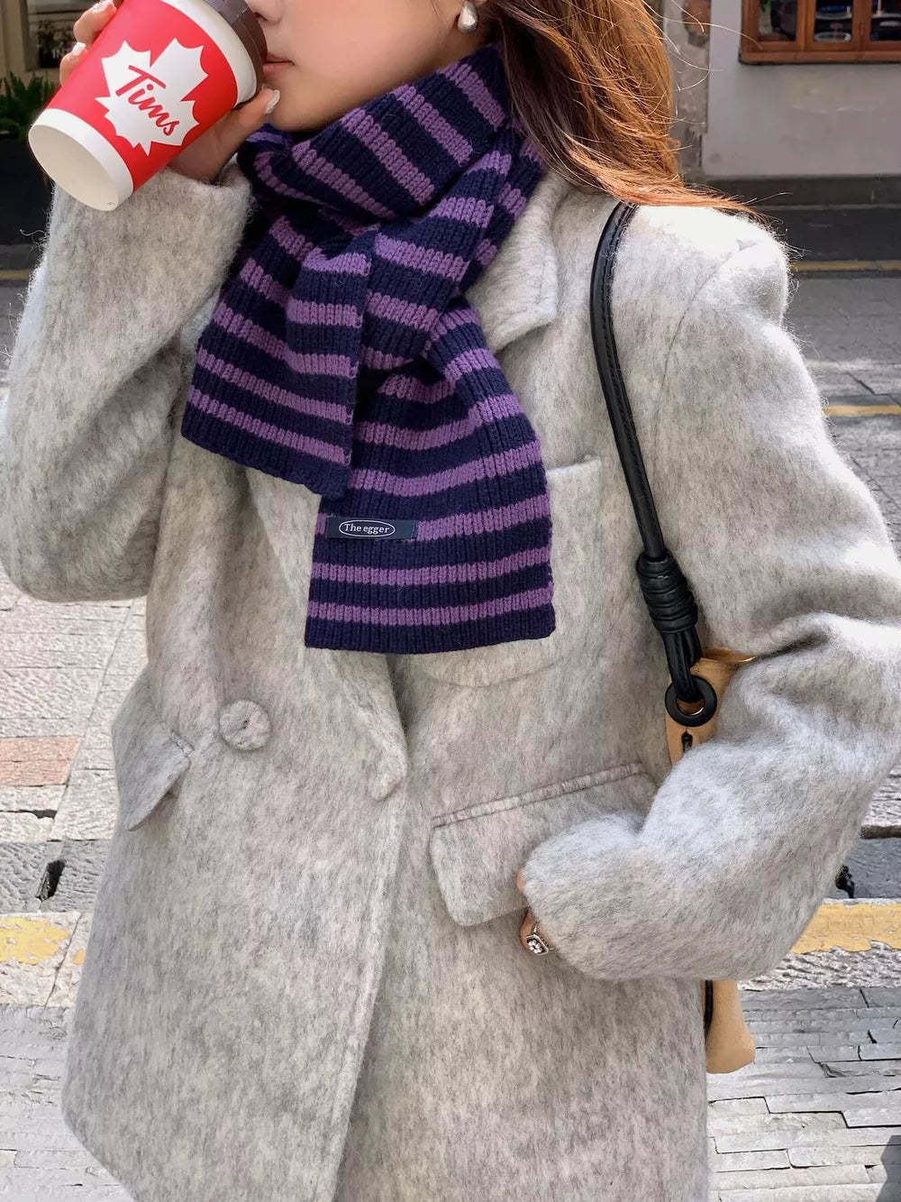 Cozy wool striped winter scarf in navy and purple with a small tag detail.