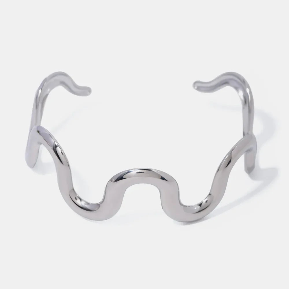 Sculptural ripple cuff bracelet in silver with a wavy, artistic design.