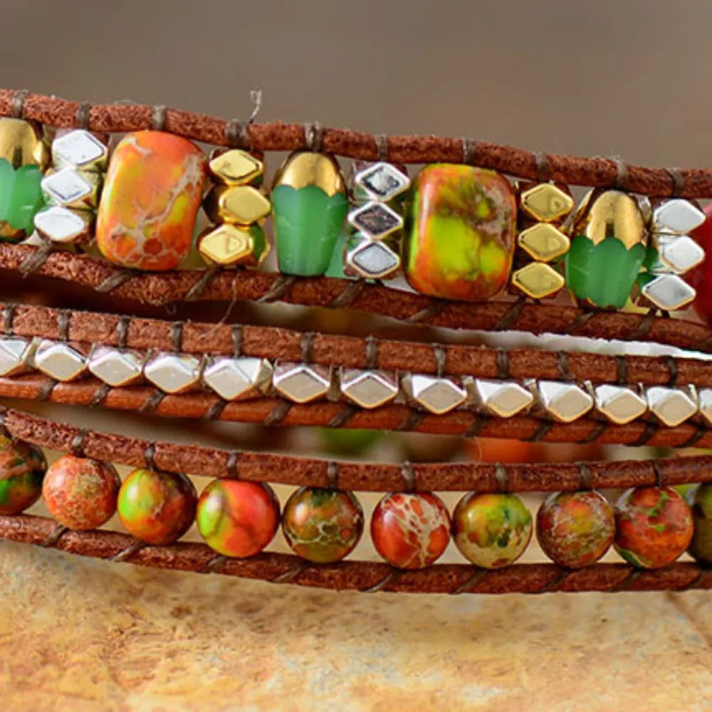 Wrapped leather bracelet with orange, green, and gold gemstone beads.