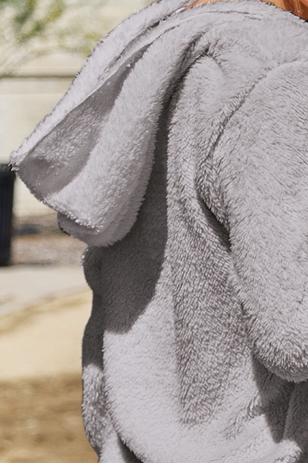 Plush hooded cardigan jacket in light gray with a soft texture.