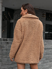 Camel teddy moto jacket with collared neckline and asymmetrical detail.