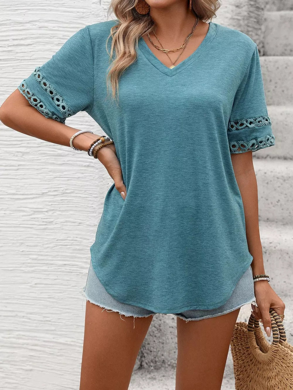 Blue-green V-neck t-shirt with lace trim on sleeves.